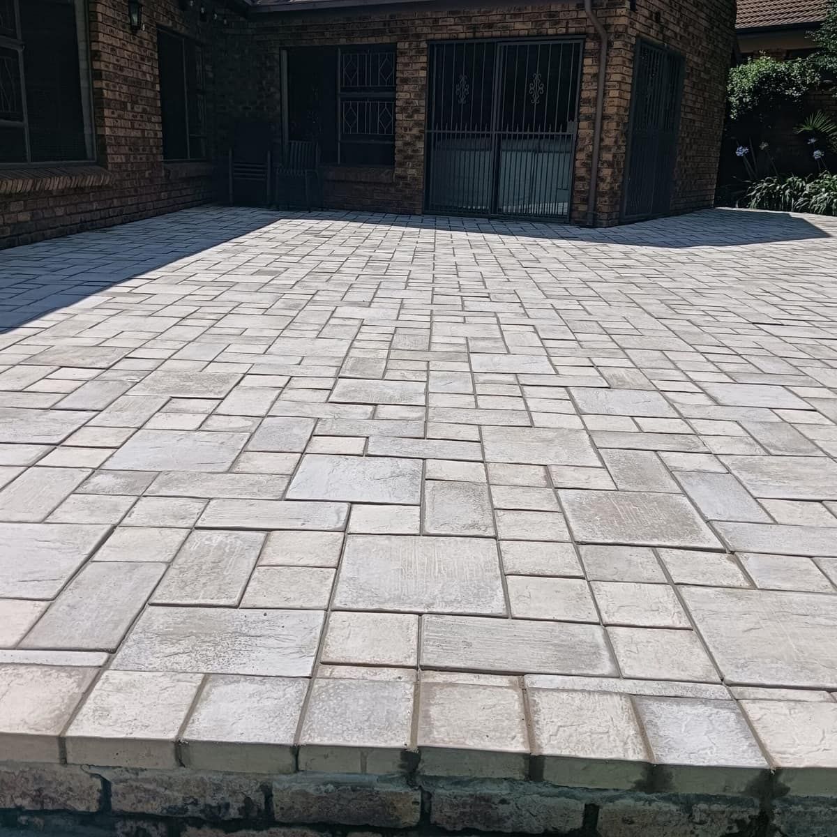cream paver patio at a face brick house