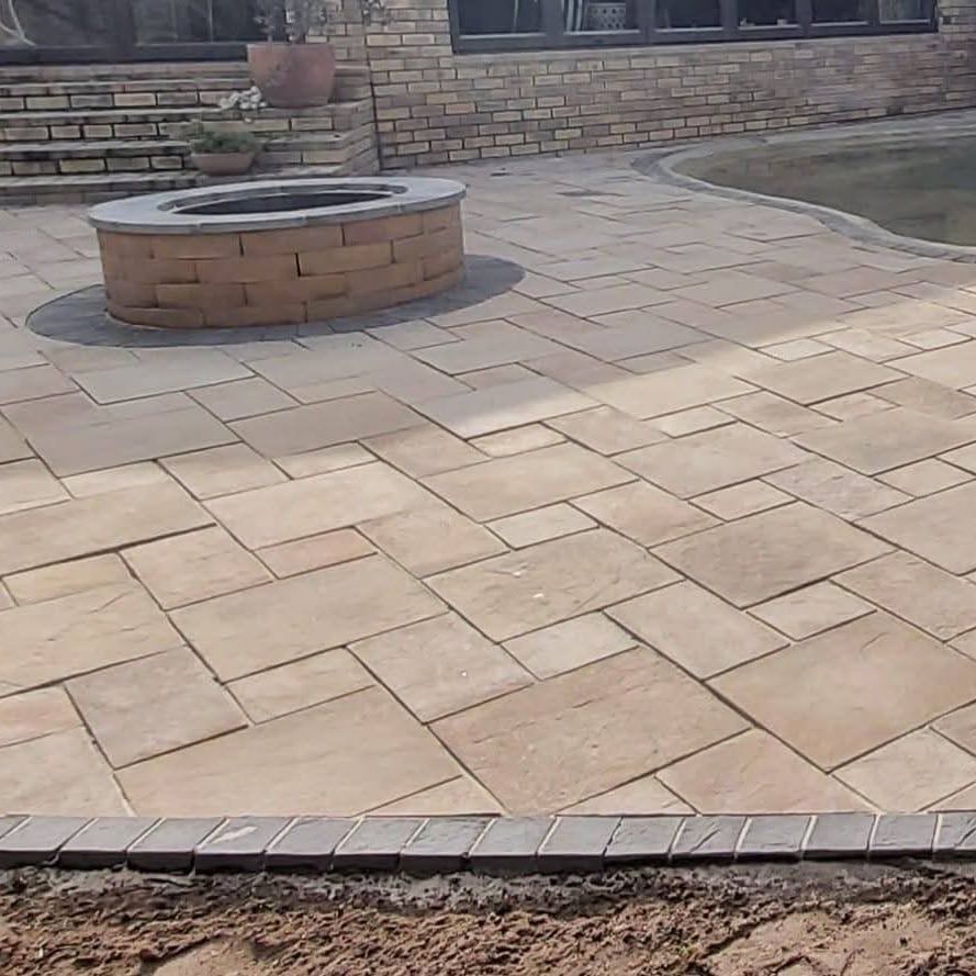 fire pit on a sandstone coloured paver patio