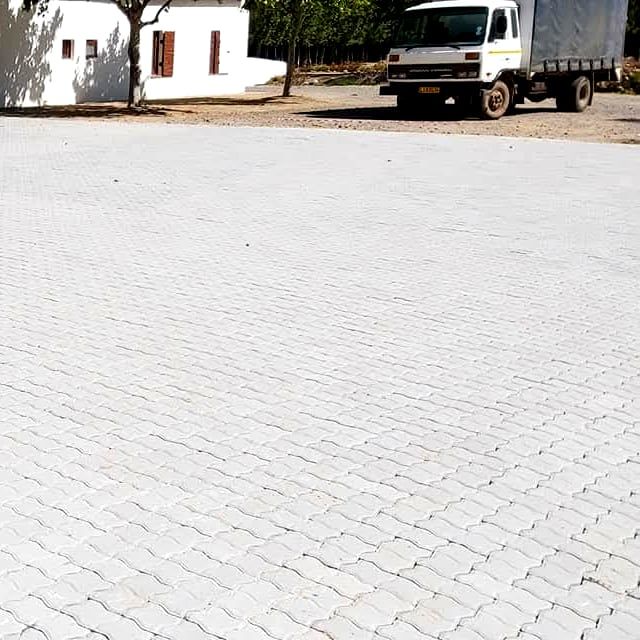 interlocking paver yard at a white building with a truck