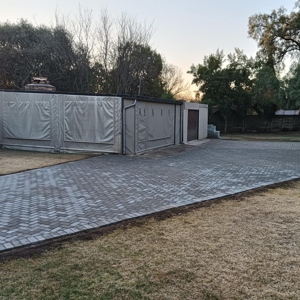 paving in grey herringbone beside an outbuilding at sunset